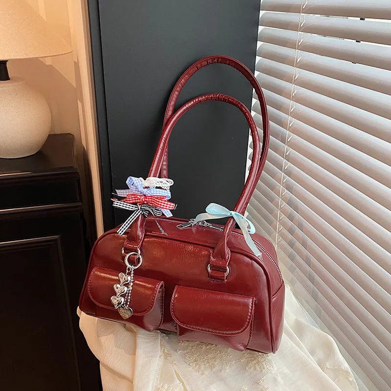 Retro brown PU leather women's pillow bag with double shoulder straps and a flap top closure.