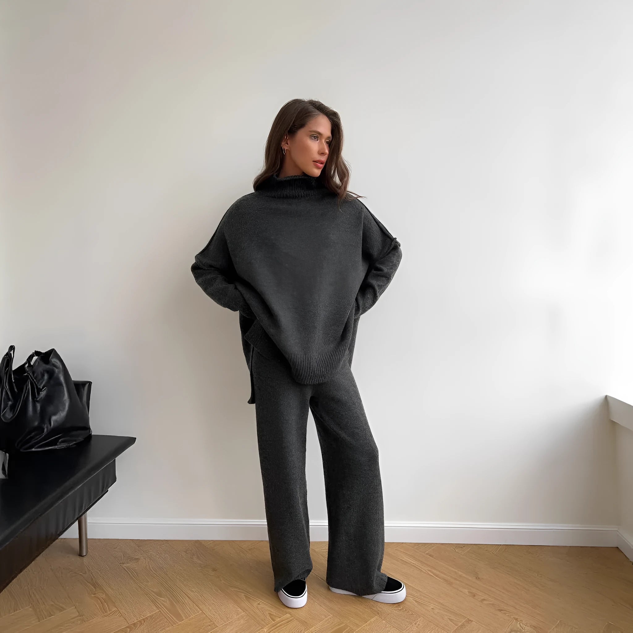 Women's dark grey acrylic knitted sweater with side slits and matching trousers.