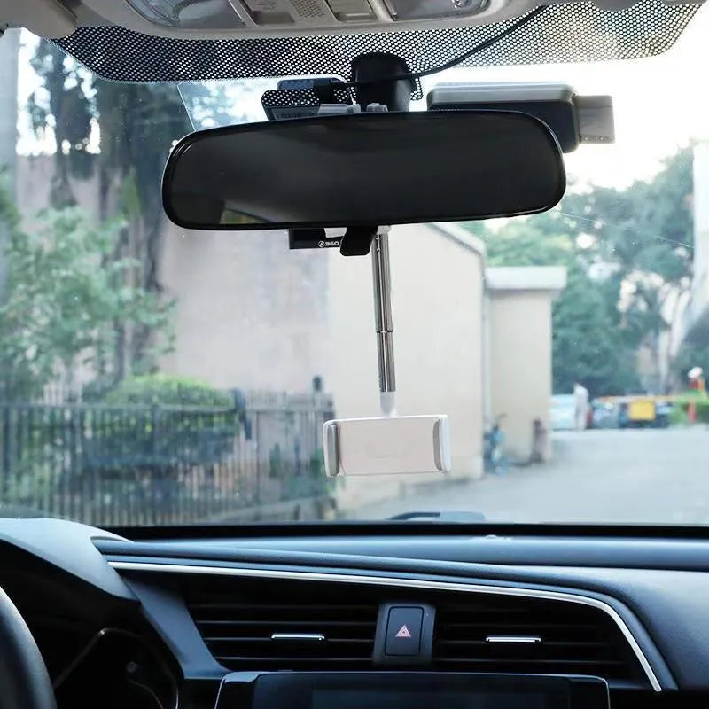 Black ABS plastic mobile phone bracket mounted on a car rearview mirror holding a smartphone