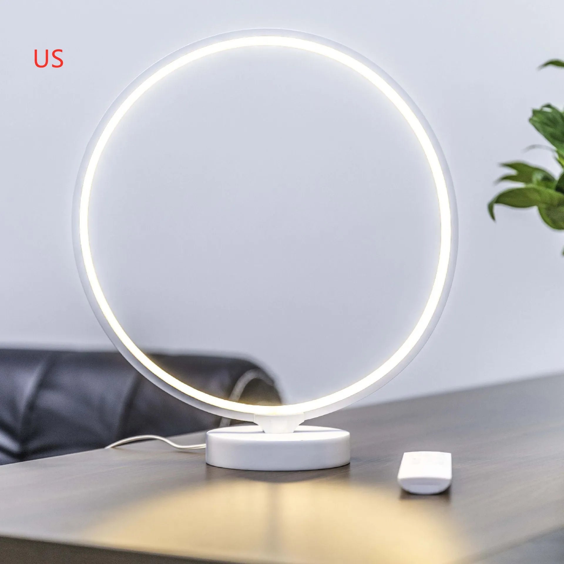White Full Moon mood lamp with remote control on a table.