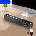 G18 black and white compact desktop computer speaker with USB cable on a wooden desk