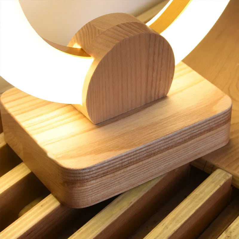 Nordic style circular wooden art chandelier with acrylic shade hanging from a ceiling.
