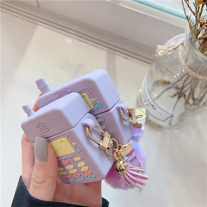 Purple silicone protective case for Apple AirPods with a small furry purple pendant attached.
