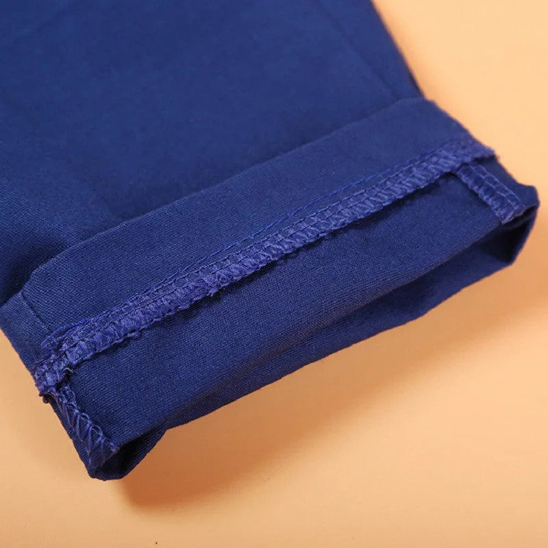 Blue boys smart clothing set with turtleneck, waistcoat, tie, and trousers on a hanger