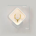 Deer antler shaped wall light with remote control on a plain wall, showing white and black colour options.