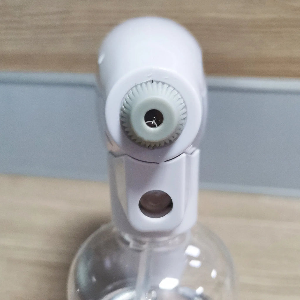 White cordless handheld disinfectant spray gun with USB-C charging port and bottle attached.