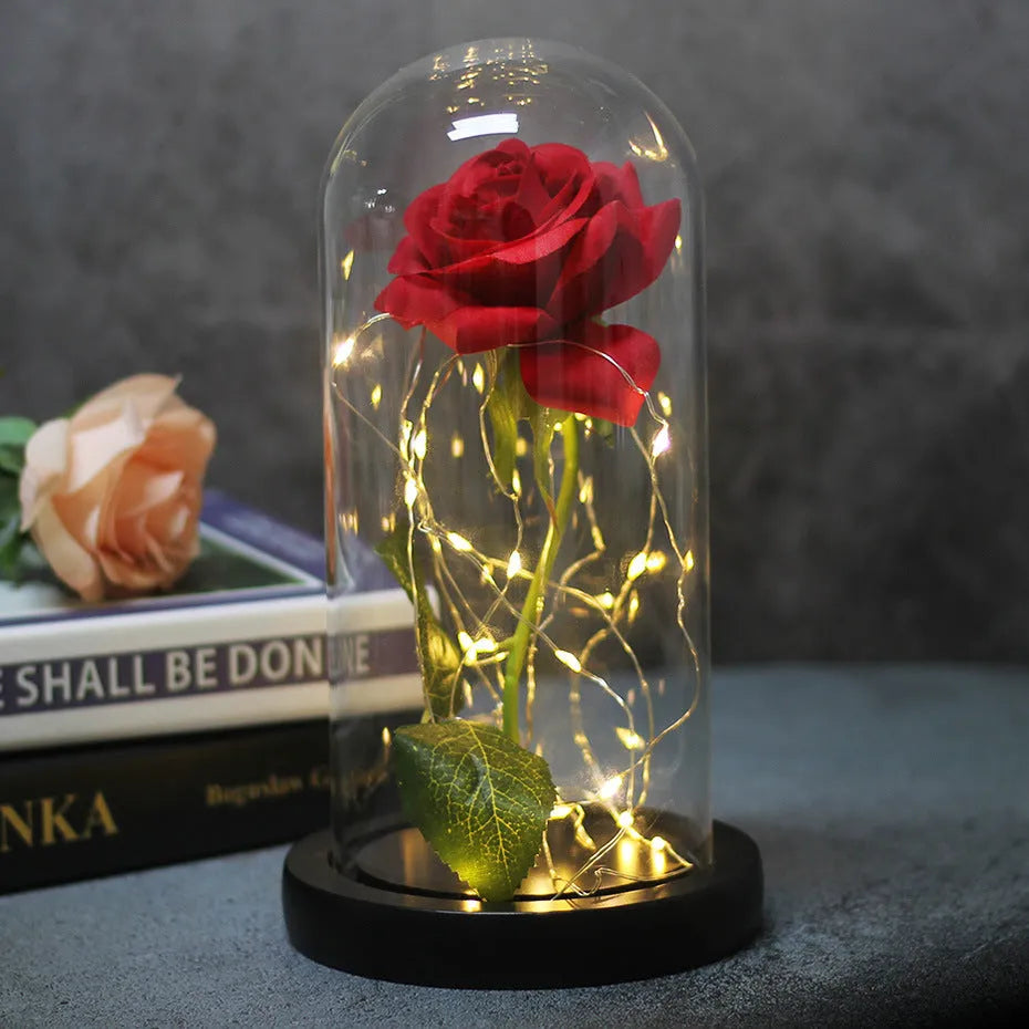 Simulated scarlet rose LED bouquet glowing inside a glass dome on a wooden base.