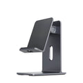 Dark grey alloy mobile phone holder holding a smartphone on a desktop.