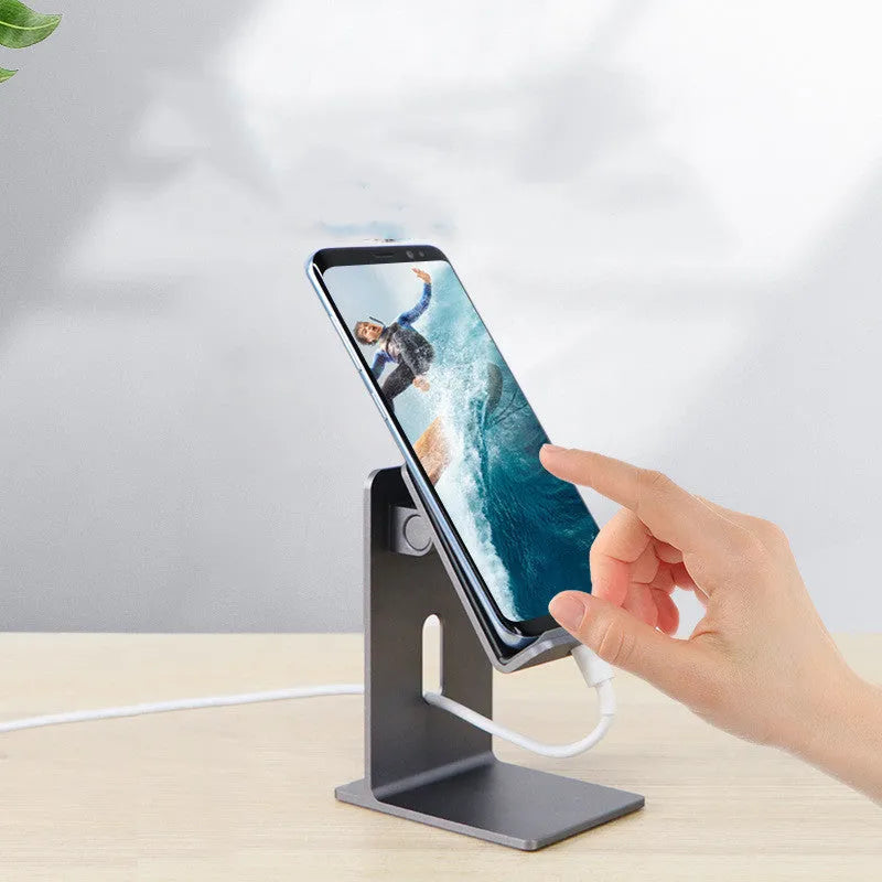 Dark grey alloy mobile phone holder holding a smartphone on a desktop.