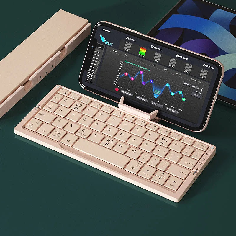 Silver folding Bluetooth keyboard propping up smartphone with hidden stand extended