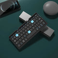 Silver folding Bluetooth keyboard propping up smartphone with hidden stand extended