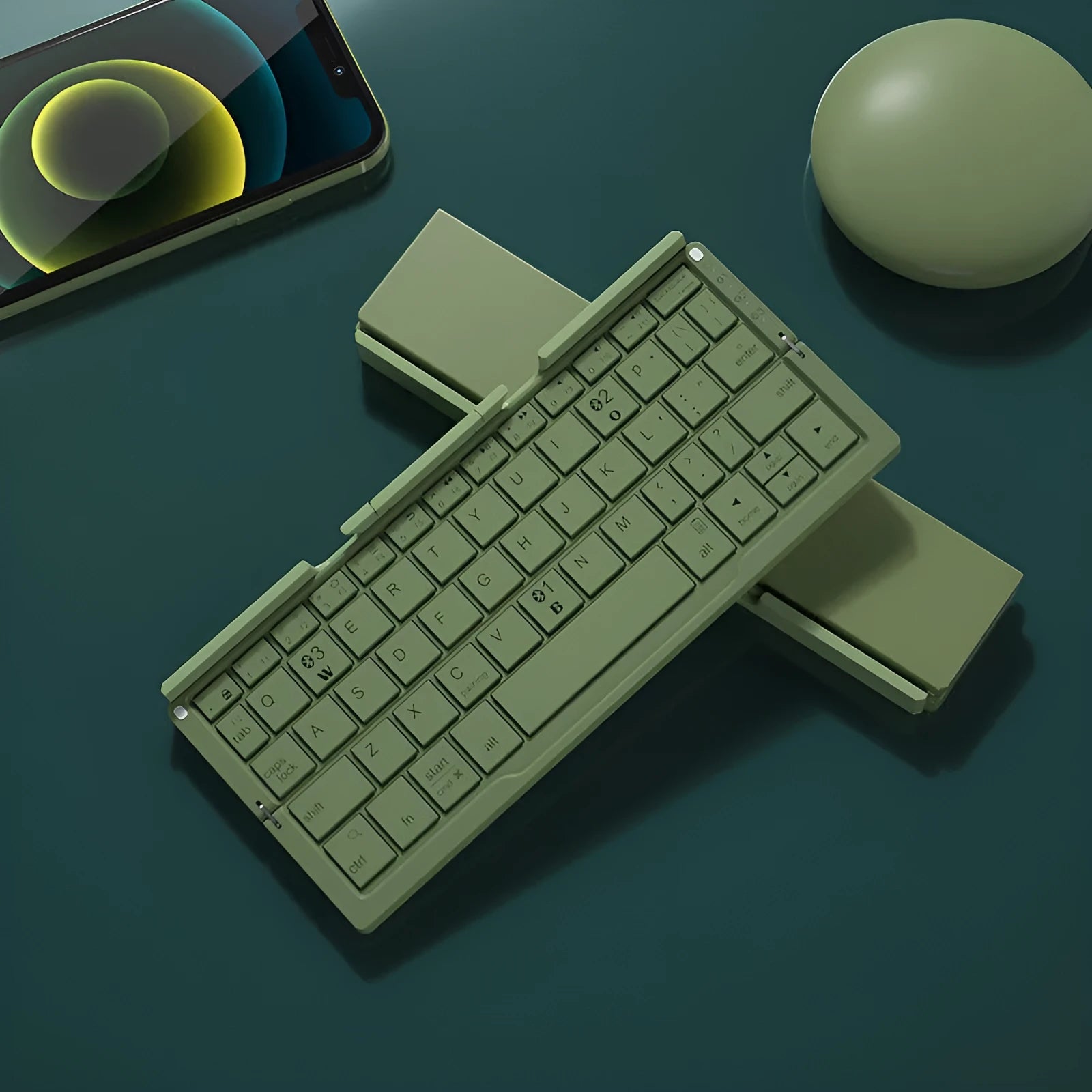 Silver folding Bluetooth keyboard propping up smartphone with hidden stand extended