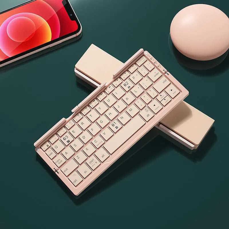 Silver folding Bluetooth keyboard propping up smartphone with hidden stand extended