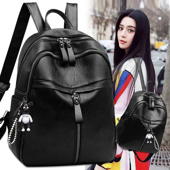 Black soft PU leather backpack with double straps and a zipper opening, showing its medium size.
