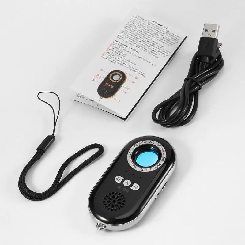 Compact black wireless signal detector and anti-theft alarm with vibration sensor, shown next to a ruler for scale.