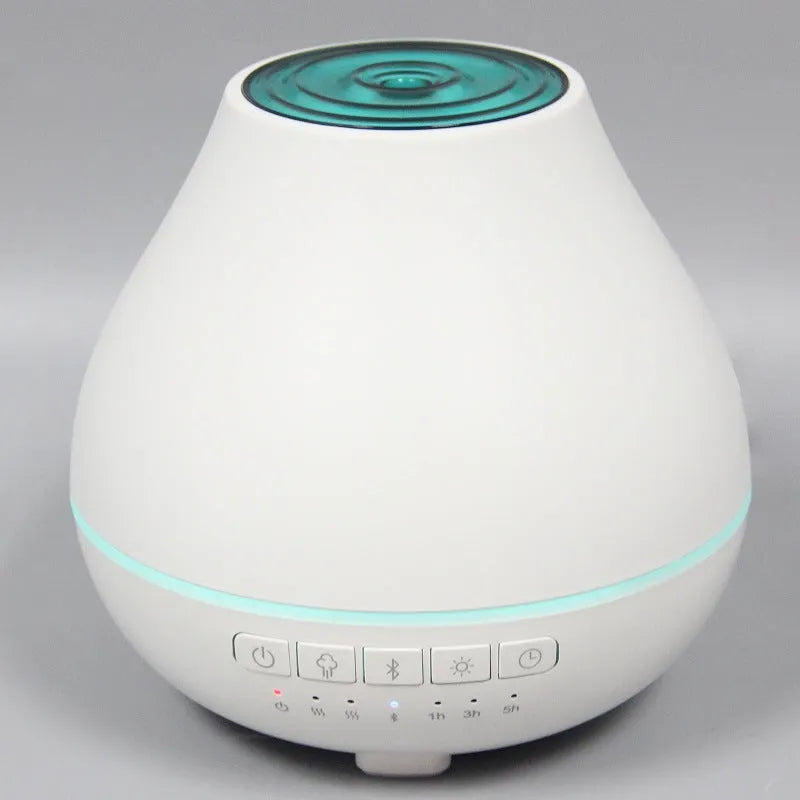 White circular Bluetooth humidifier and aroma diffuser with night light on a wooden surface.