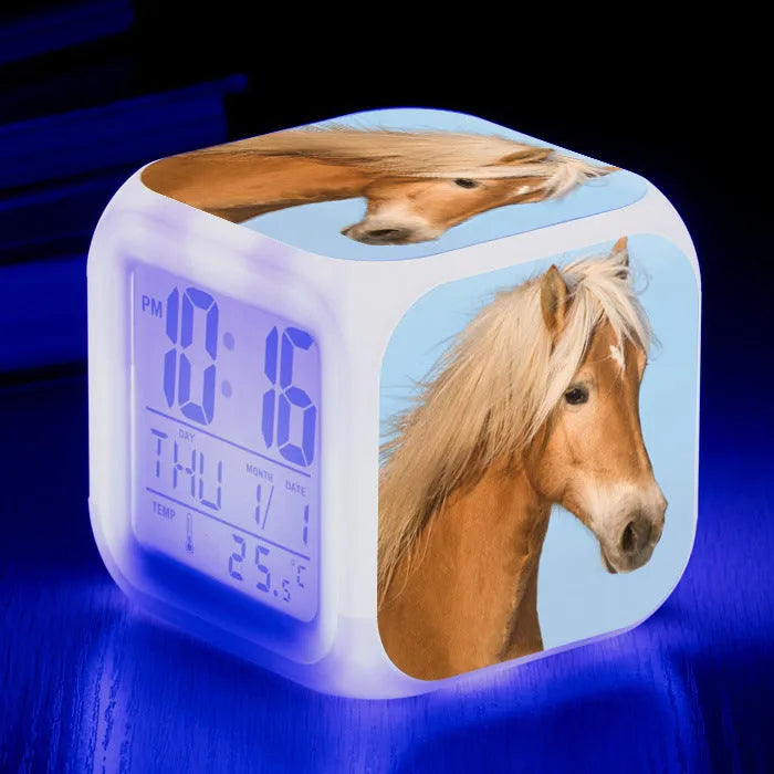 Square cartoon LED digital alarm clock showing time, temperature, and weekday on luminous display.