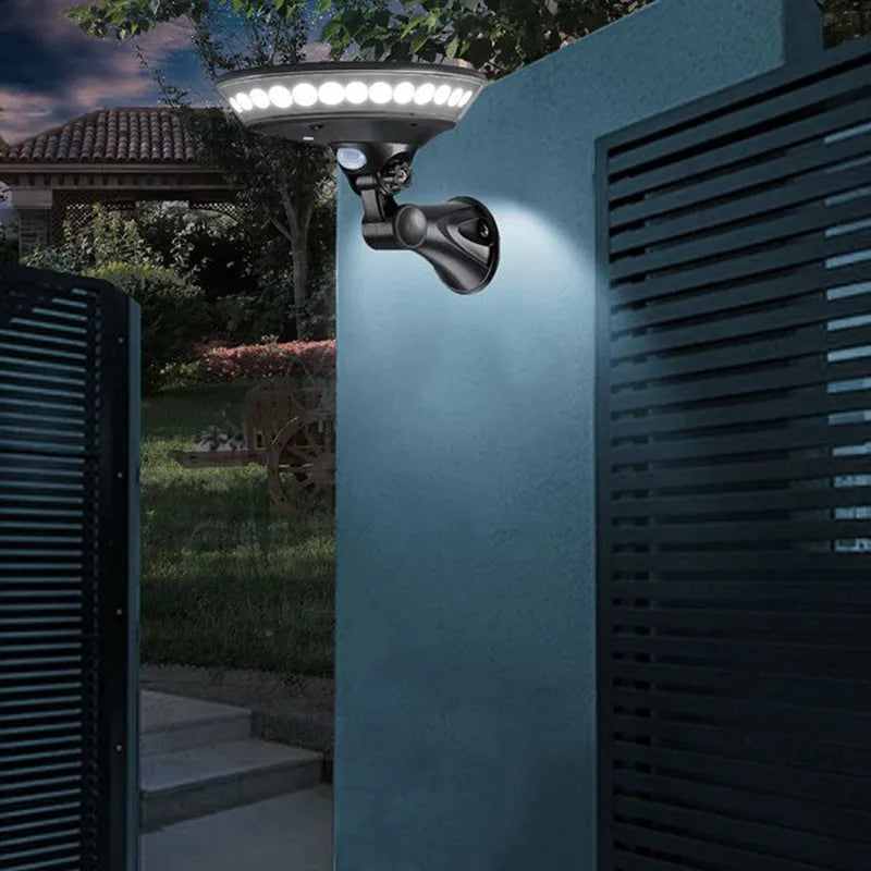White ABS plastic 360-degree solar security light with solar panel on top, mounted on an outdoor wall.