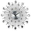 Large round silver wall clock with numbers and metal frame on a wall.