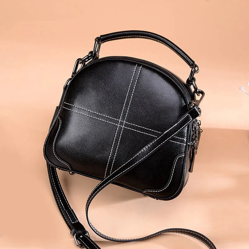 Genuine cowhide leather round handbag with soft handle and zipper closure