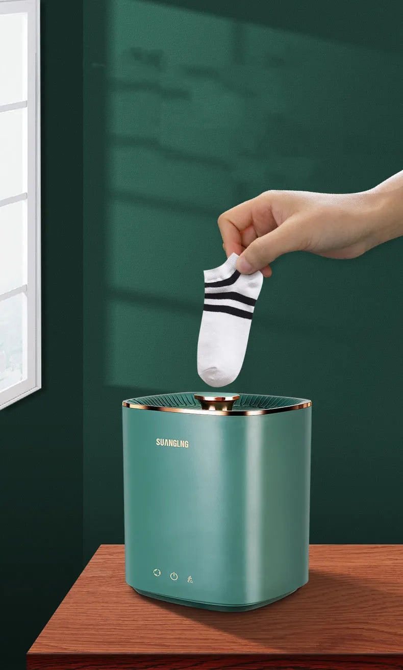 Green portable mini automatic washing machine for underwear and travel on a white surface.