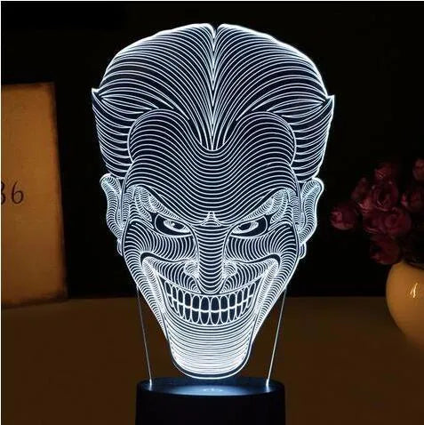USB-powered 3D acrylic LED lamp showing seven colour options and remote control on a desk.