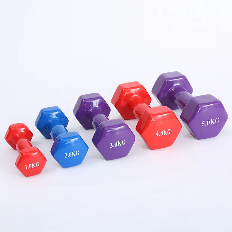 Bright colourful plastic dumbbell for fitness with glossy surface on wooden floor