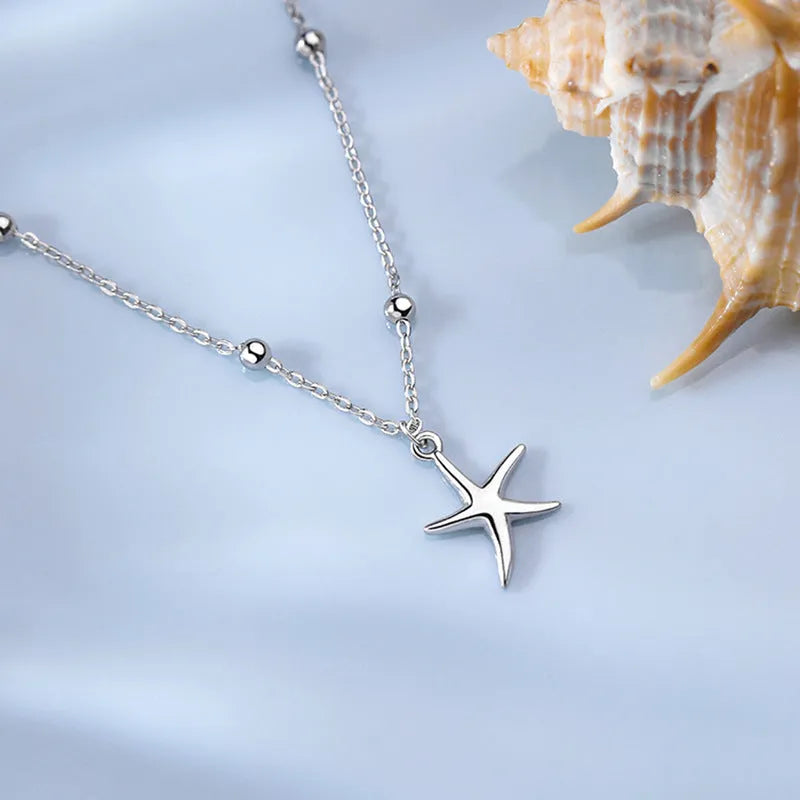 Sterling silver starfish charm anklet with round beads on an adjustable chain.
