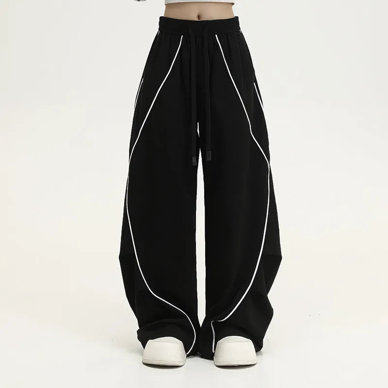 Black pleated hip hop sports pants with stripe pattern showing wide-leg design and mid-waist fit