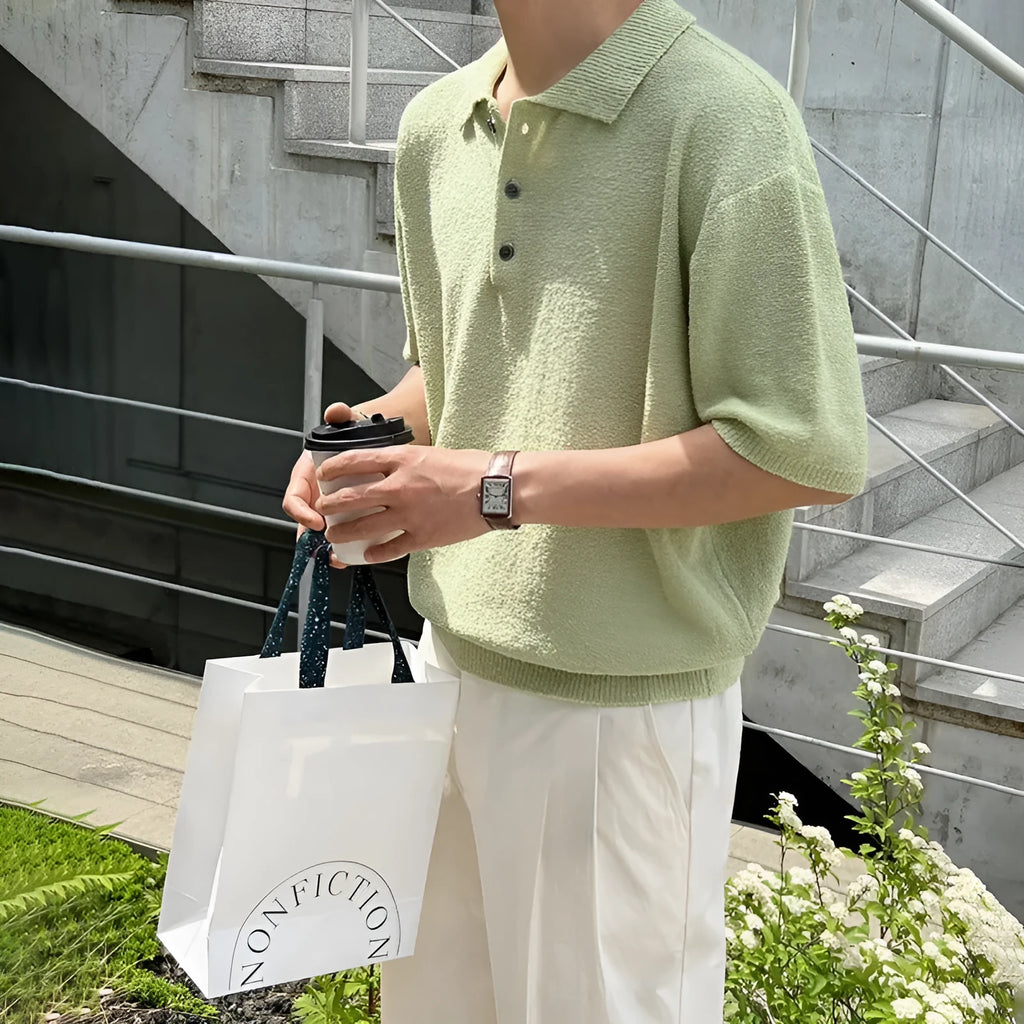 Man wearing a caramel coloured retro knitted polo shirt with short sleeves and an asymmetric design detail.