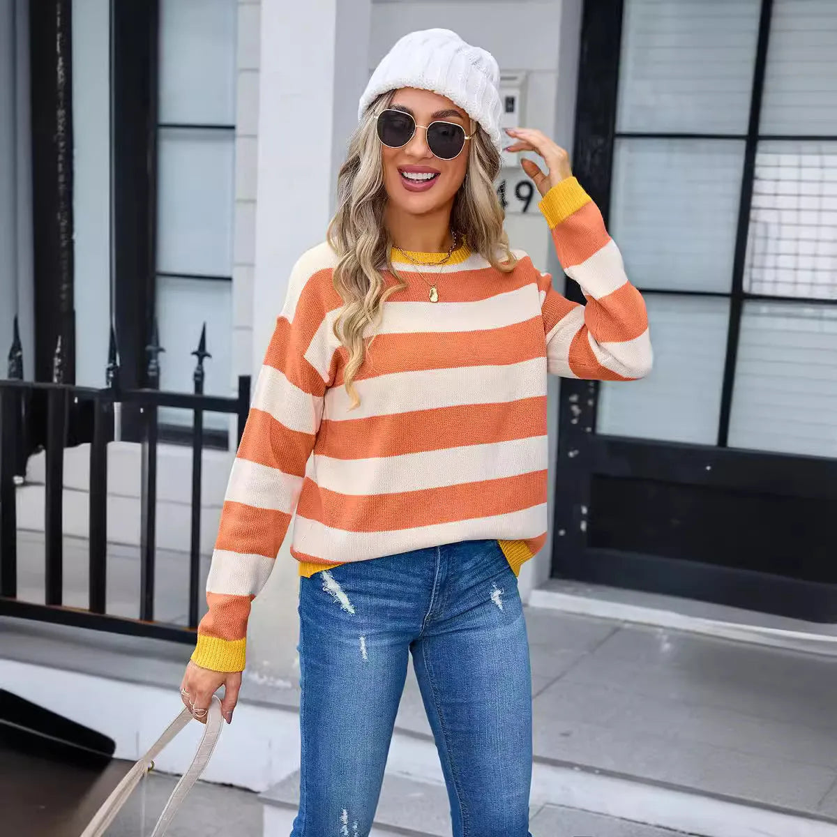 Women's loose blue striped acrylic long sleeve round neck sweater on a hanger