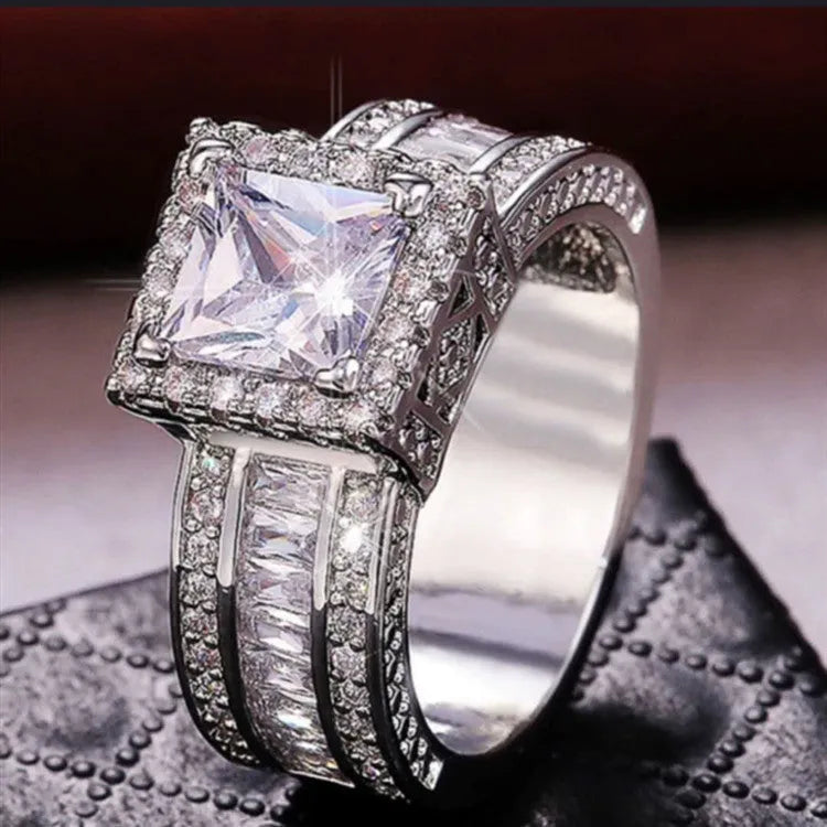 Geometric silver-fashion women's ring in gold or white colour on a grey background.