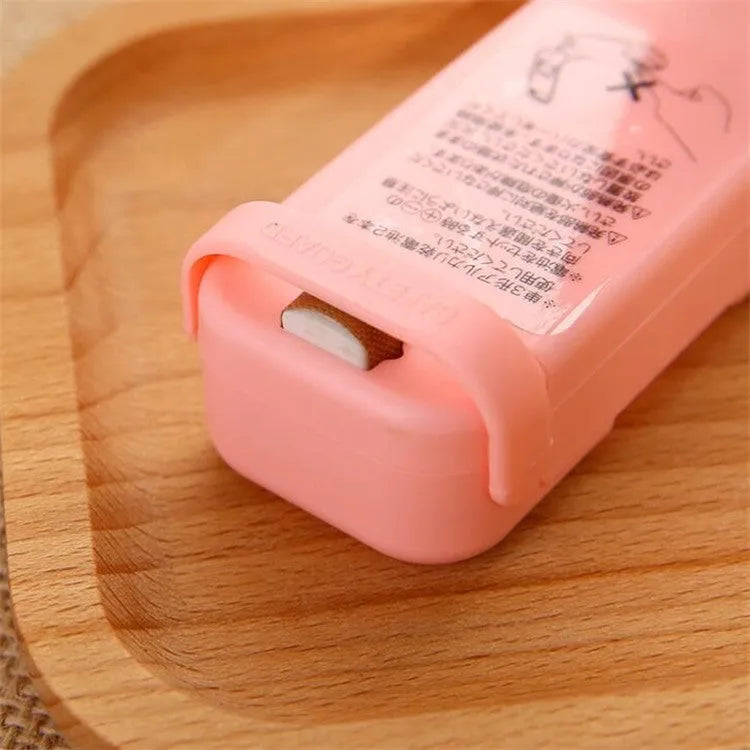 Household food clip portable mini plastic bag sealer heat sealing machine in pink on white background