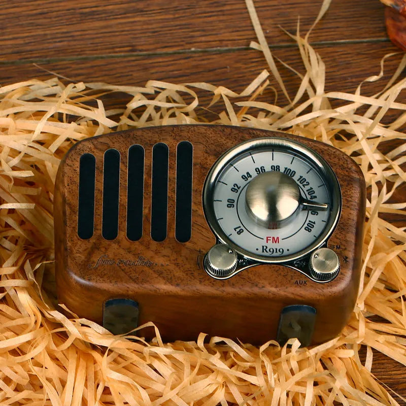 Retro wooden wireless mini speaker in cherry wood finish on a wooden table.