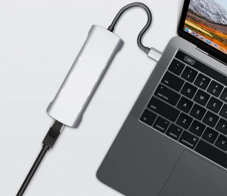 Grey USB-C docking station with aluminium alloy shell showing HDMI, VGA and USB ports
