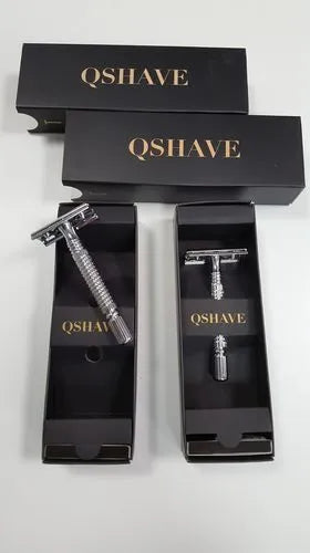 Chrome double edged safety razor with brass handle and closed comb head on storage box.