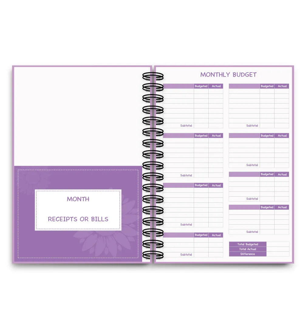 Purple coil-bound financial planning notebook open on a desk with pen, stickers, and paper clips.