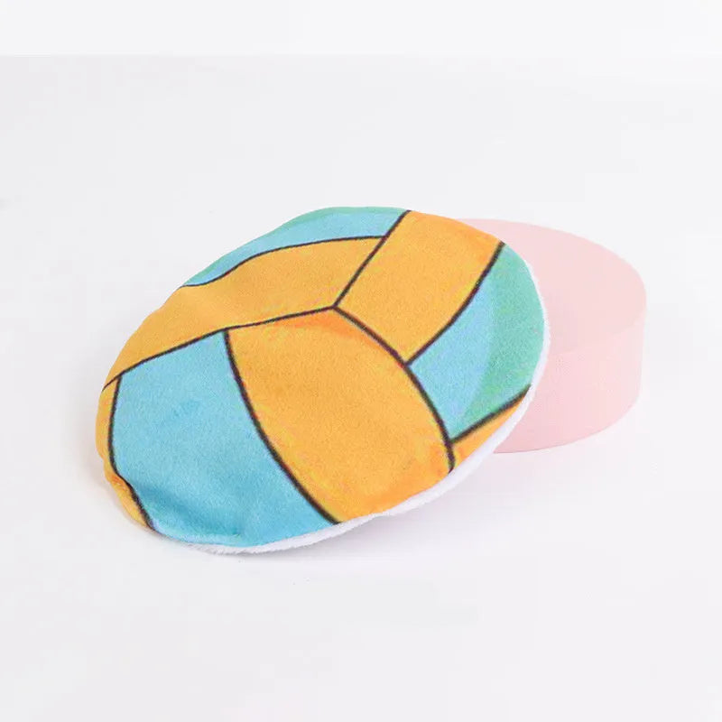 Small, flat, plush flying disc cat toy with a sport ball pattern, containing catnip and a crinkle sound element.