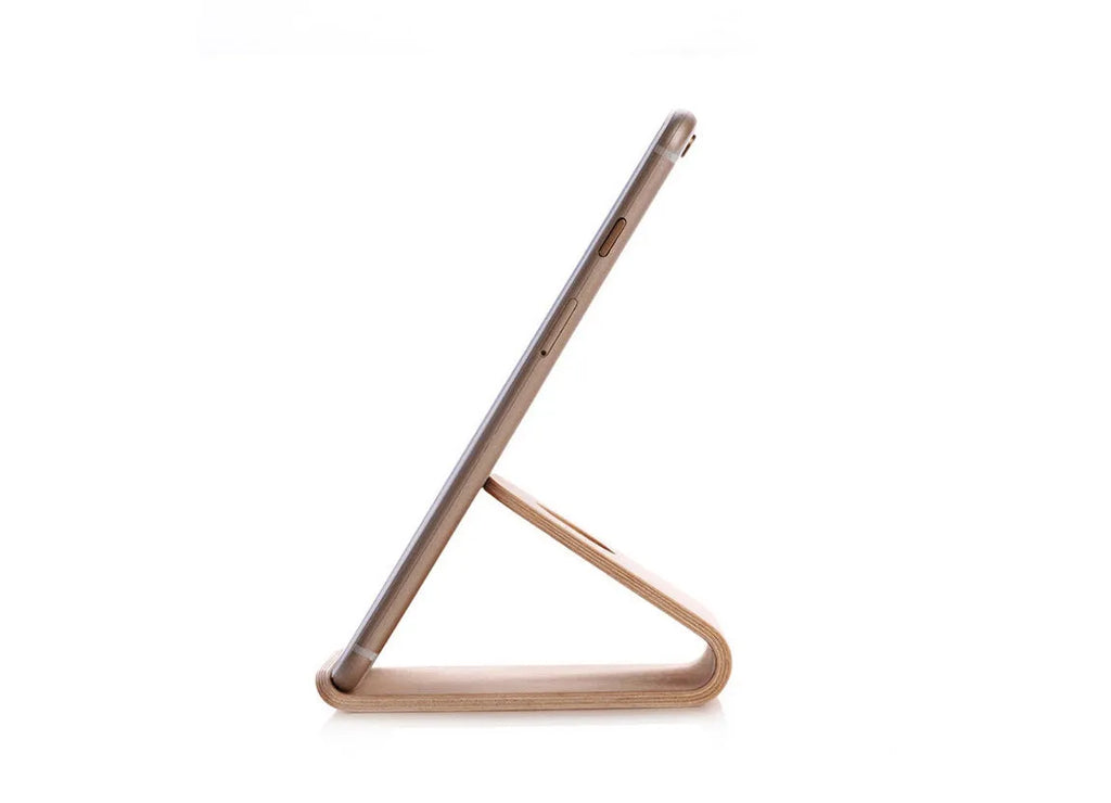 Wooden stand for iPhone in Walnut finish, placed on a desk, holding a phone for hands-free viewing
