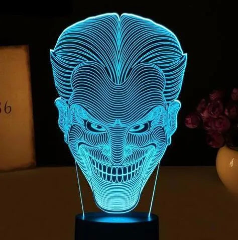 USB-powered 3D acrylic LED lamp showing seven colour options and remote control on a desk.