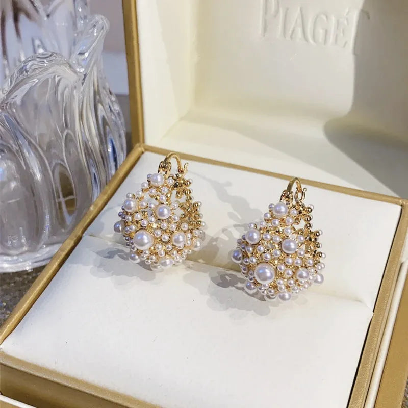 Gold tone copper flower basket shaped earrings with small rice-shaped pearl inlay beads.