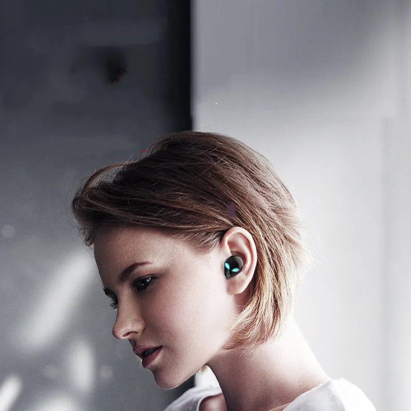 Creative Outer T8 Starman alien design Bluetooth headset with red LED lights and wireless charging case.