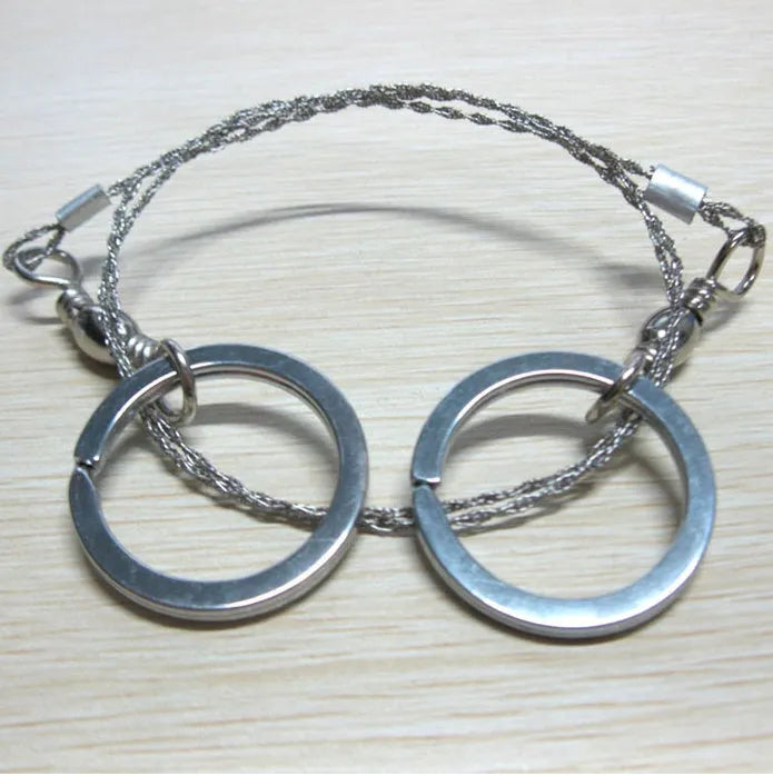 Stainless steel survival wire saw with thumb rings showing 55cm blade and compact storage size
