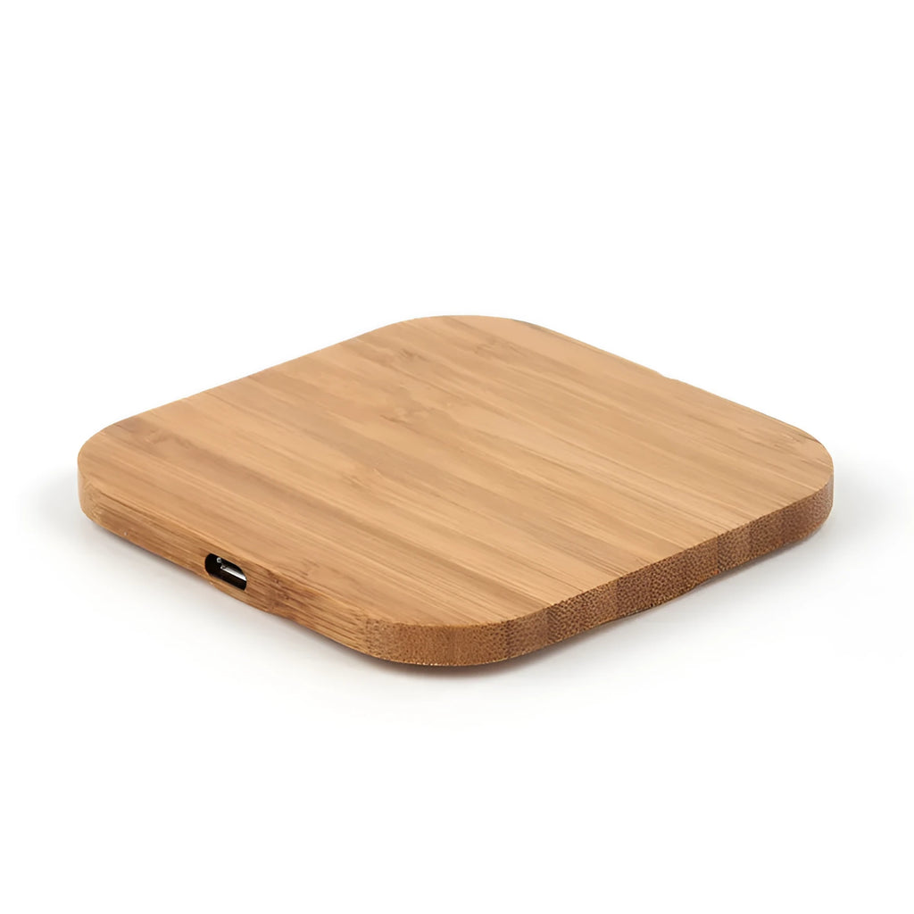 Square brown wooden bamboo wireless charging pad for phones on a desk