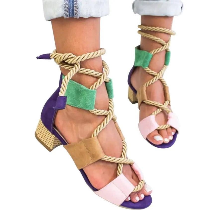 Women's beige suede sandals with thick middle heel, front strap, and ankle strap on a neutral background.