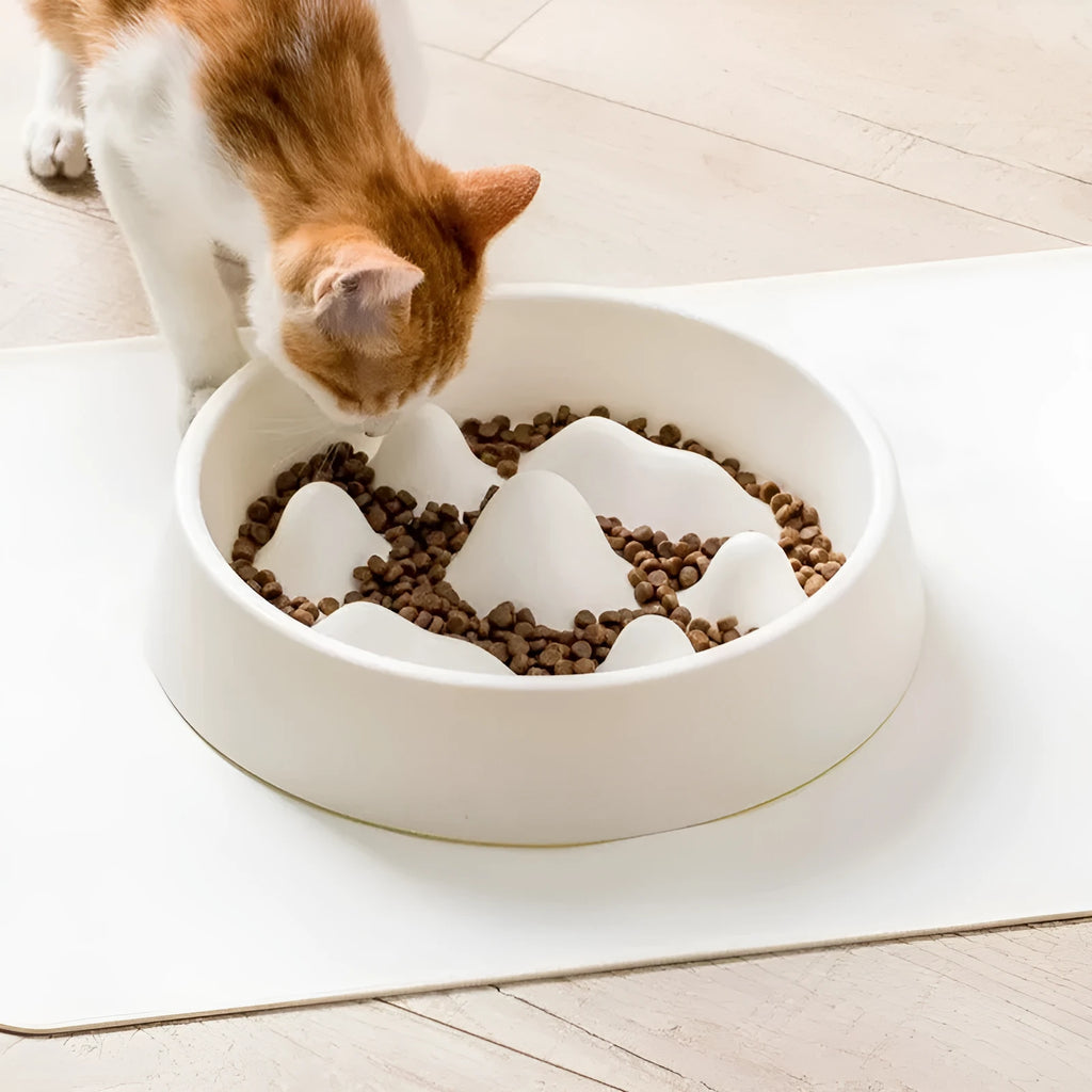 Pet slow food bowl with raised mountain bumps in off-white colour on a floor mat