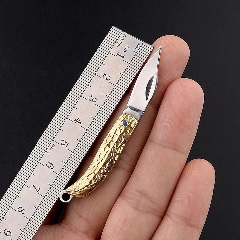 Brass mini folding knife with 3cm blade and keychain pendant on brass ring, 50mm full length model shown