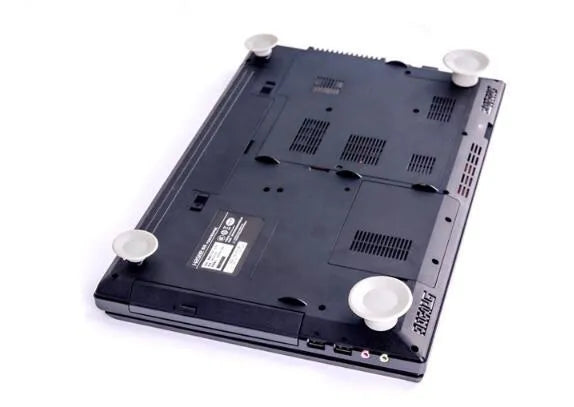 Four grey plastic non-slip laptop cooling pads, two large and two small, on a desk.