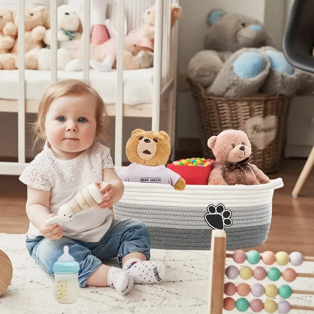 Light beige handmade cotton rope woven storage basket with handle on a wooden surface.