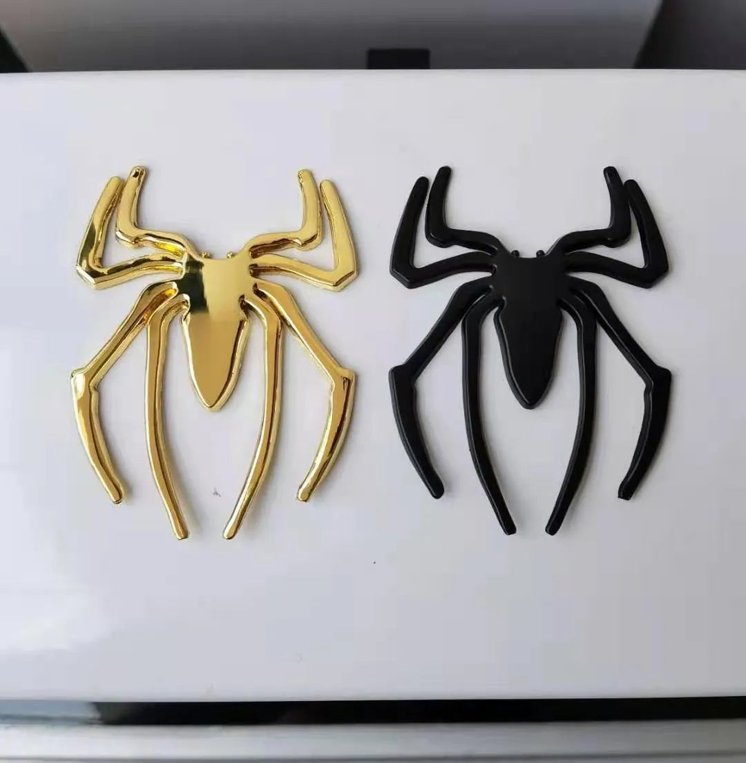 Three-dimensional metal spider bumper sticker in silver finish, measuring 7cm by 5cm.